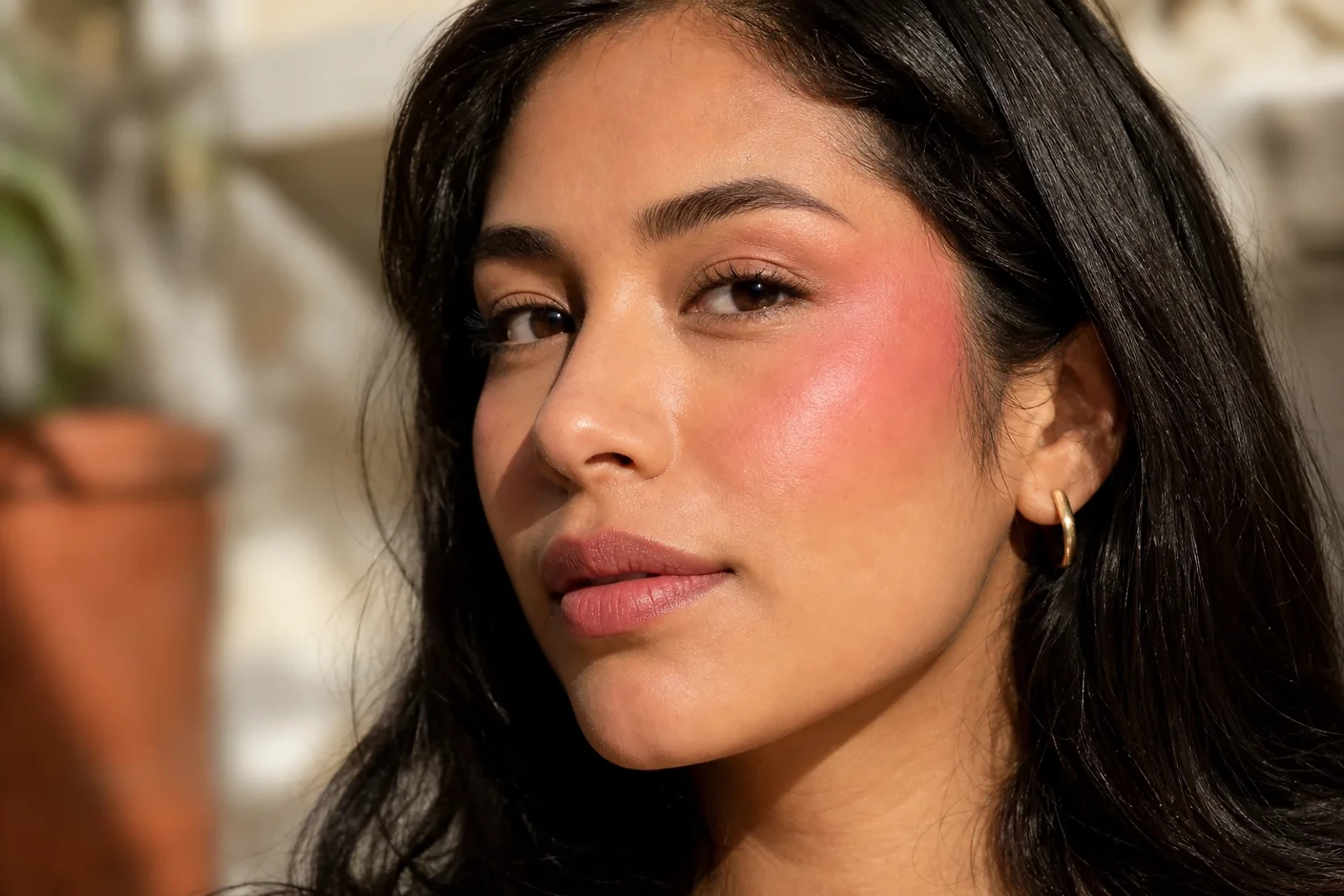 Retrato editorial de una mujer con Blush vertical ascendente hacia la sien, mostrando una tendencia de maquillaje luminosa para ZOE Salon Guatemala