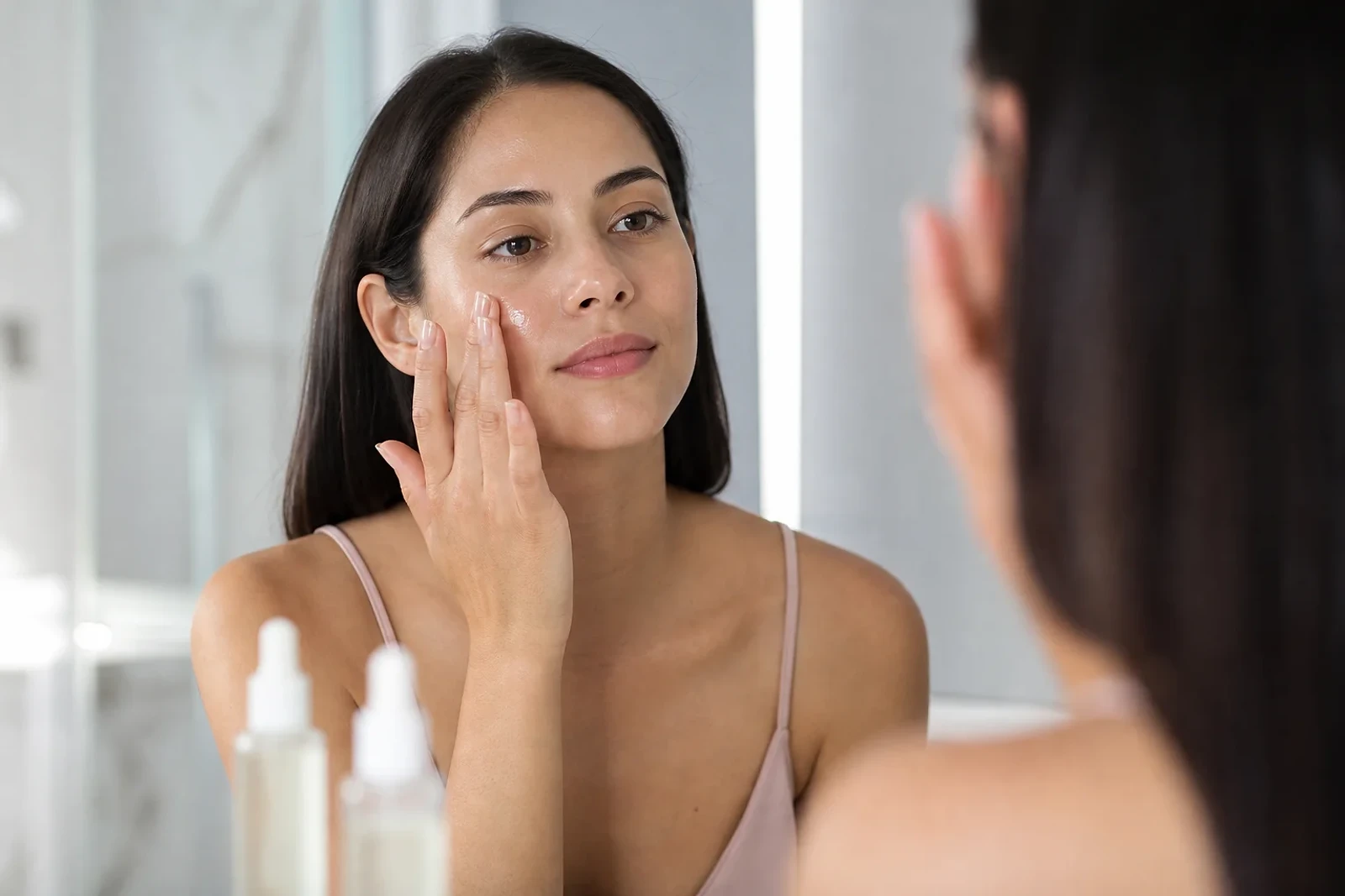Mujer adulta aplicando sérum facial en una rutina de PDRN en skincare, con piel natural e hidratada, imagen editorial de ZOE Salon Guatemala