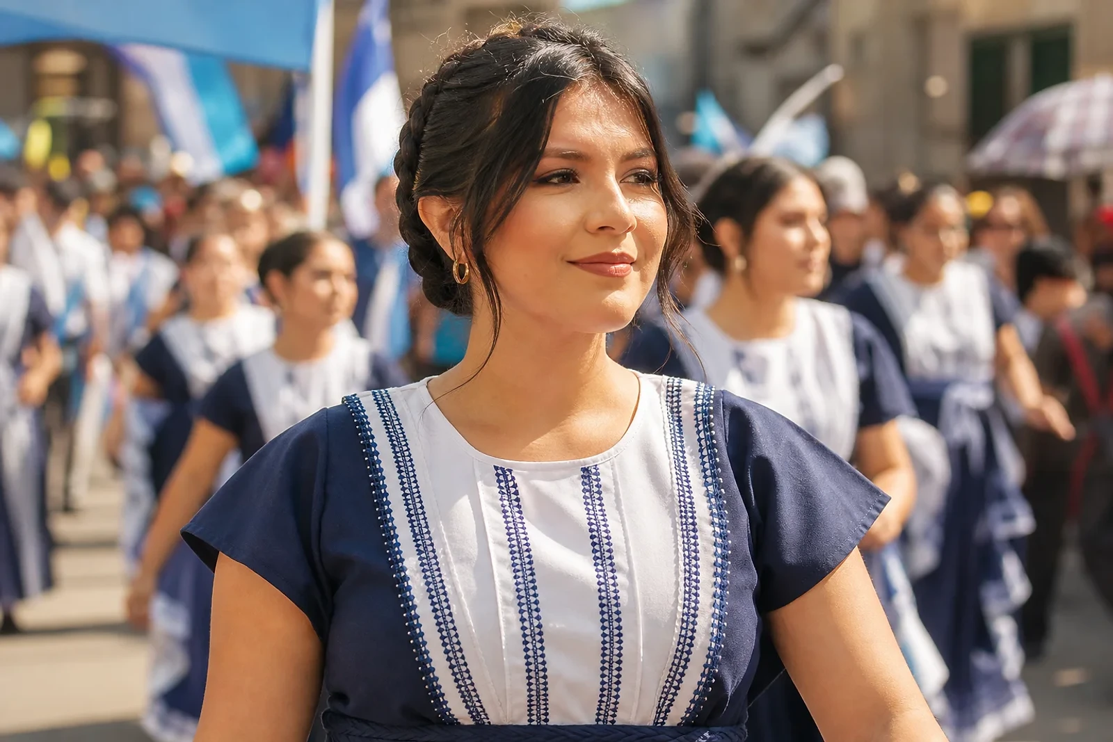 Mujer adulta con trenza francesa y detalles azul y blanco en un desfile; Peinados para desfiles Guatemala para una jornada cómoda y activa
