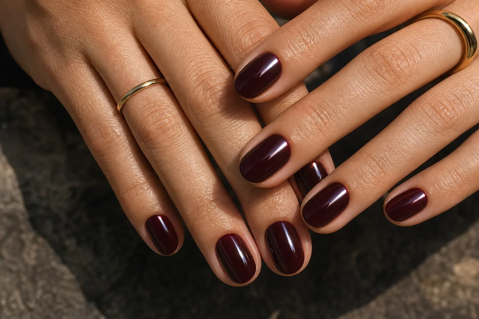 Manos con manicura merlot brillante y uñas cortas, una inspiración de Uñas color vino 2026 para un look elegante de ZOE Salon Guatemala.