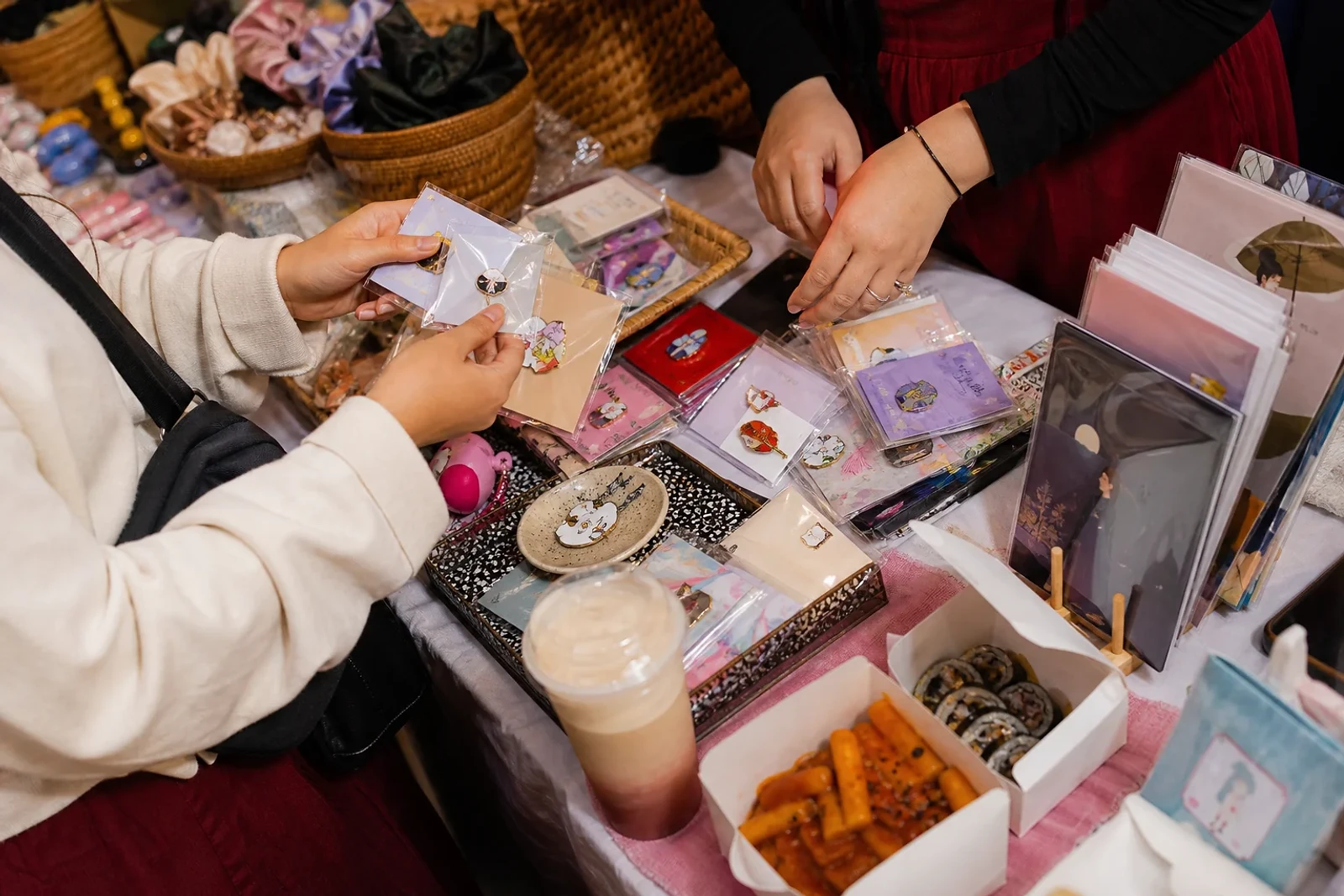 Visitantes exploran accesorios y papelería en un evento de cultura coreana; ideas de compras y planes en Guatemala para ZOE Salon Guatemala.