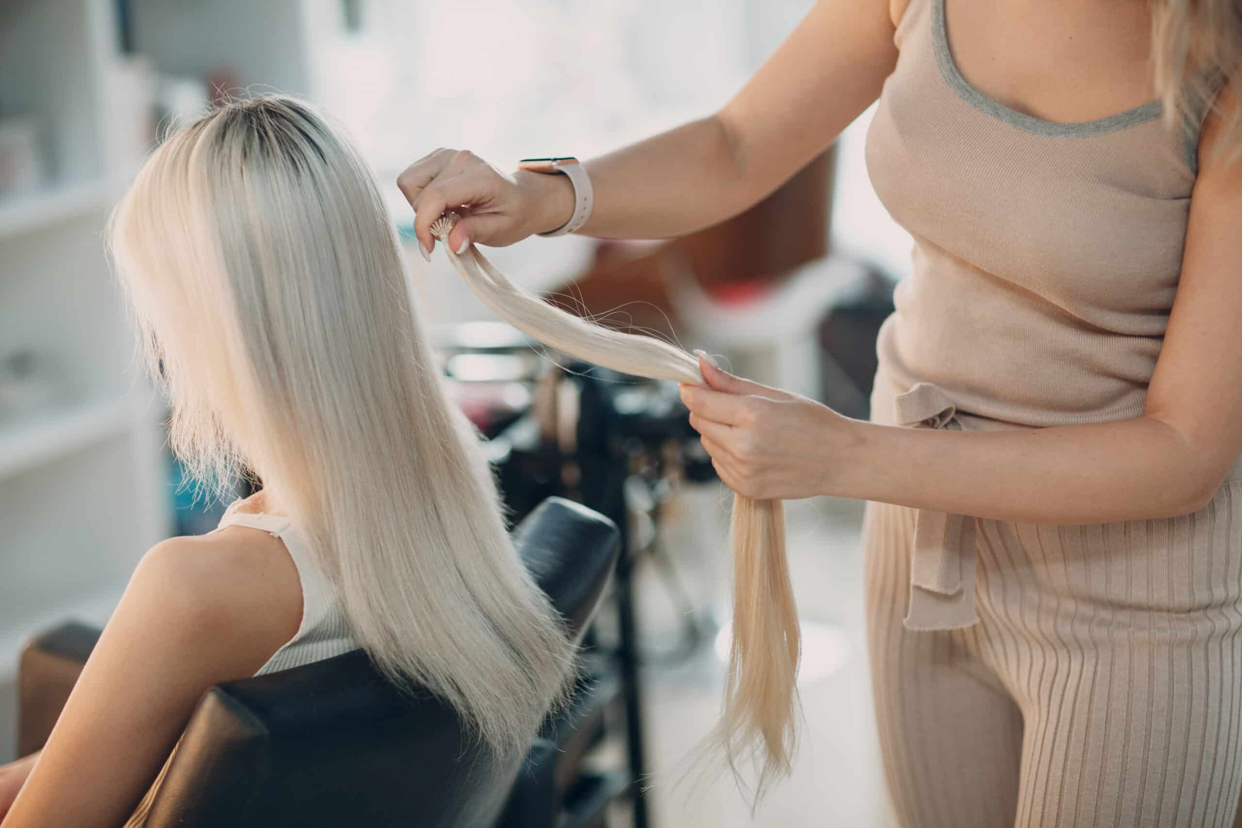 Profesional colocando extensiones de cabello en salón